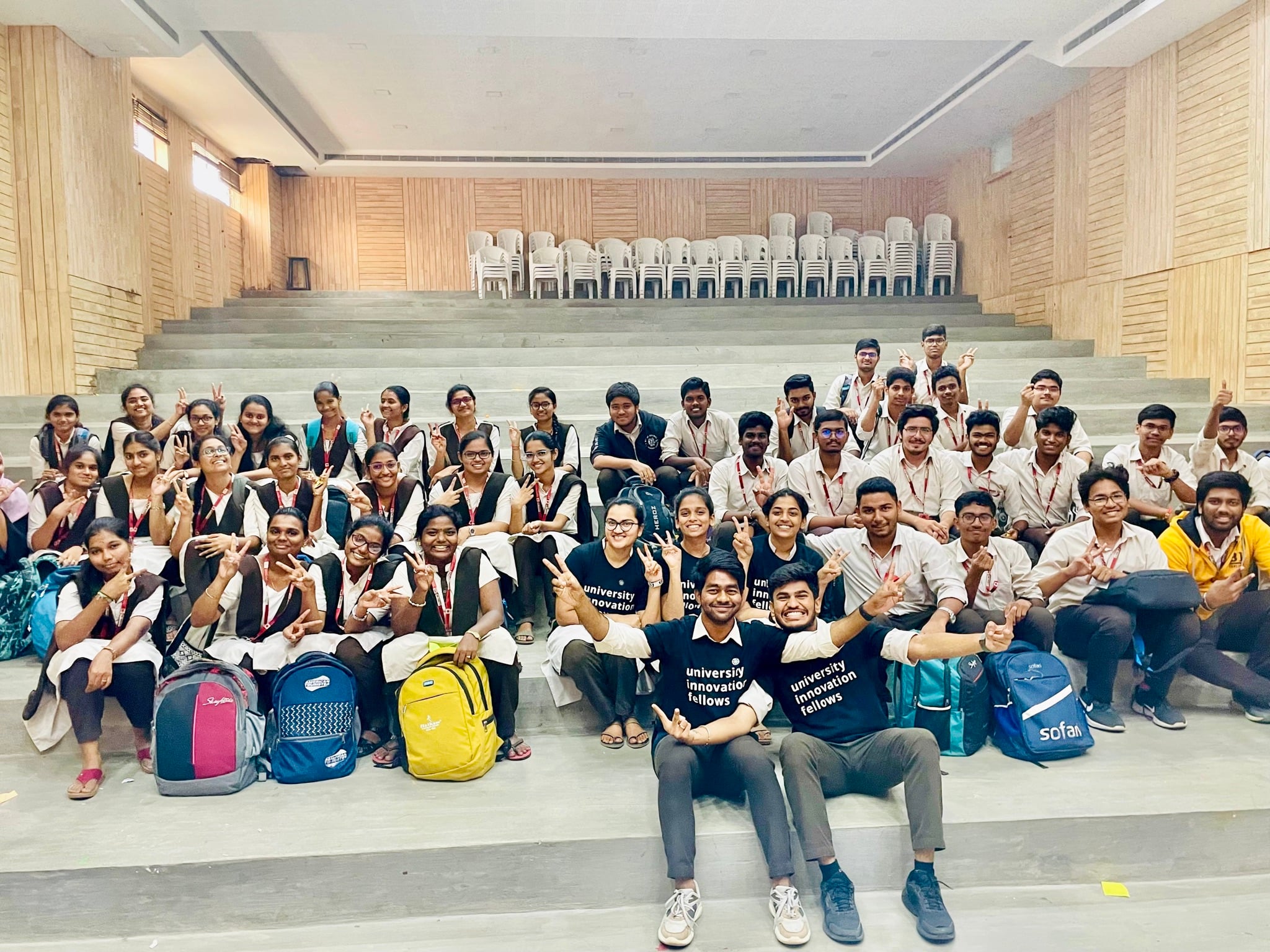 UIF team with over 60 students on amphitheater steps after a design thinking workshop